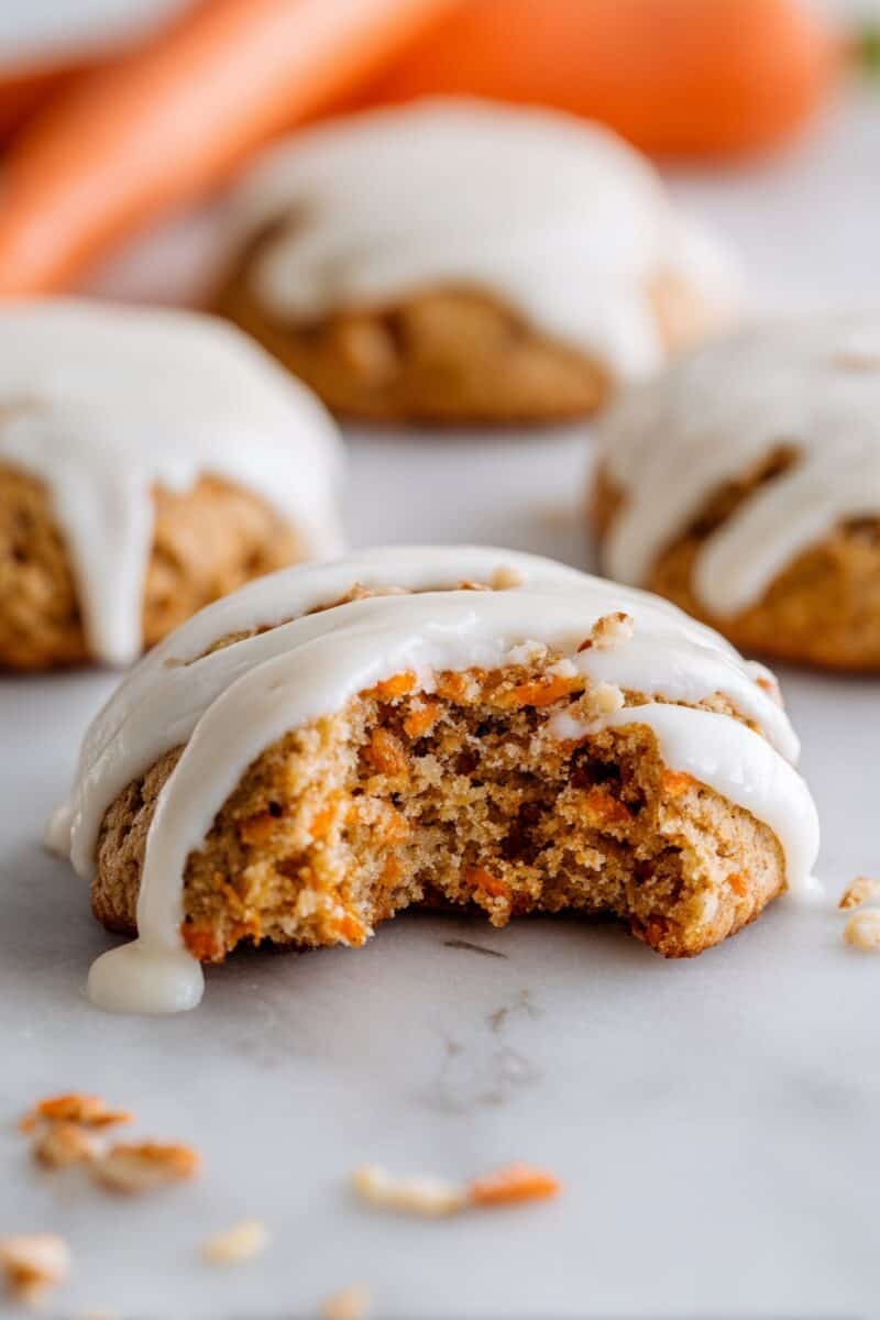 Carrot cake cookie with cream cheese glaze and a bite taken out.