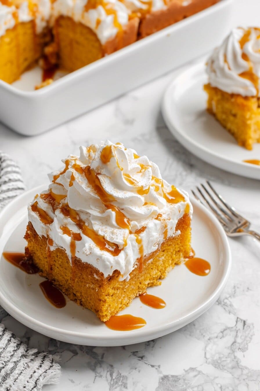 Pumpkin Tres Leches Cake slice on a white plate with visible milk-soaked layers, ideal for Friendsgiving or potluck fall desserts.