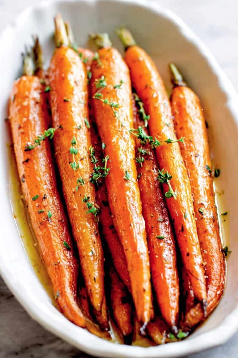 Honey roasted carrots in a white platter – tender roasted carrots with sticky honey glaze, an easy Thanksgiving vegetable side dish.