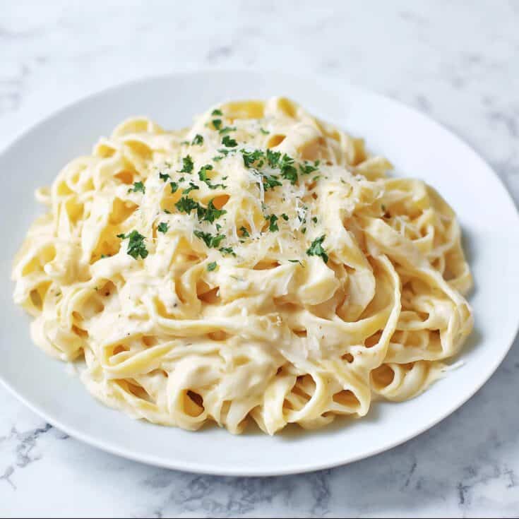 Cottage Cheese Alfredo Pasta on a white plate, creamy high protein fettuccine made with cottage cheese and Parmesan for a healthy dinner recipe