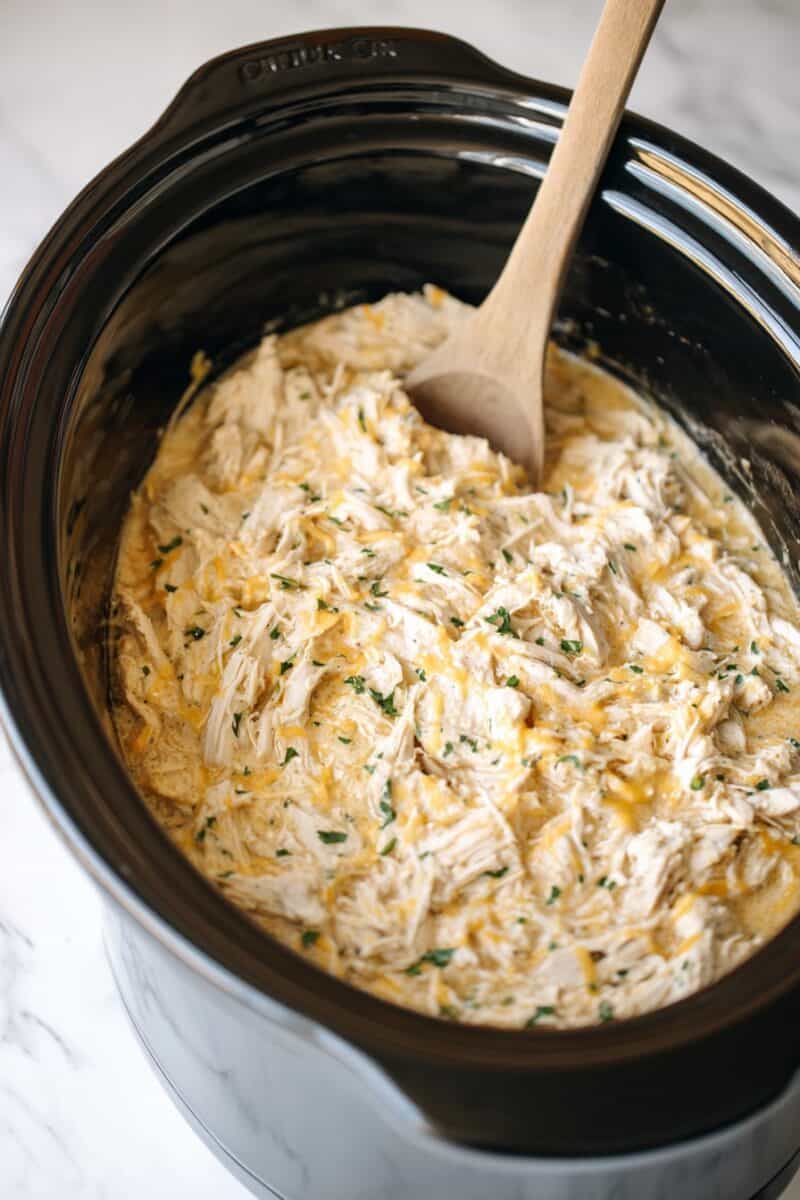 Shredded creamy ranch chicken in a crockpot showing thick sauce and tender slow cooked chicken